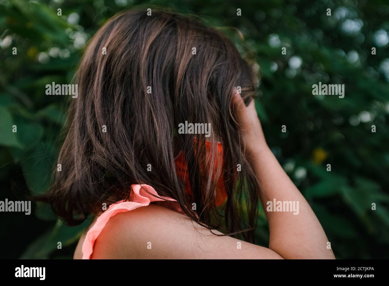 petite fille en masque orange couvrant ses yeux Banque D'Images