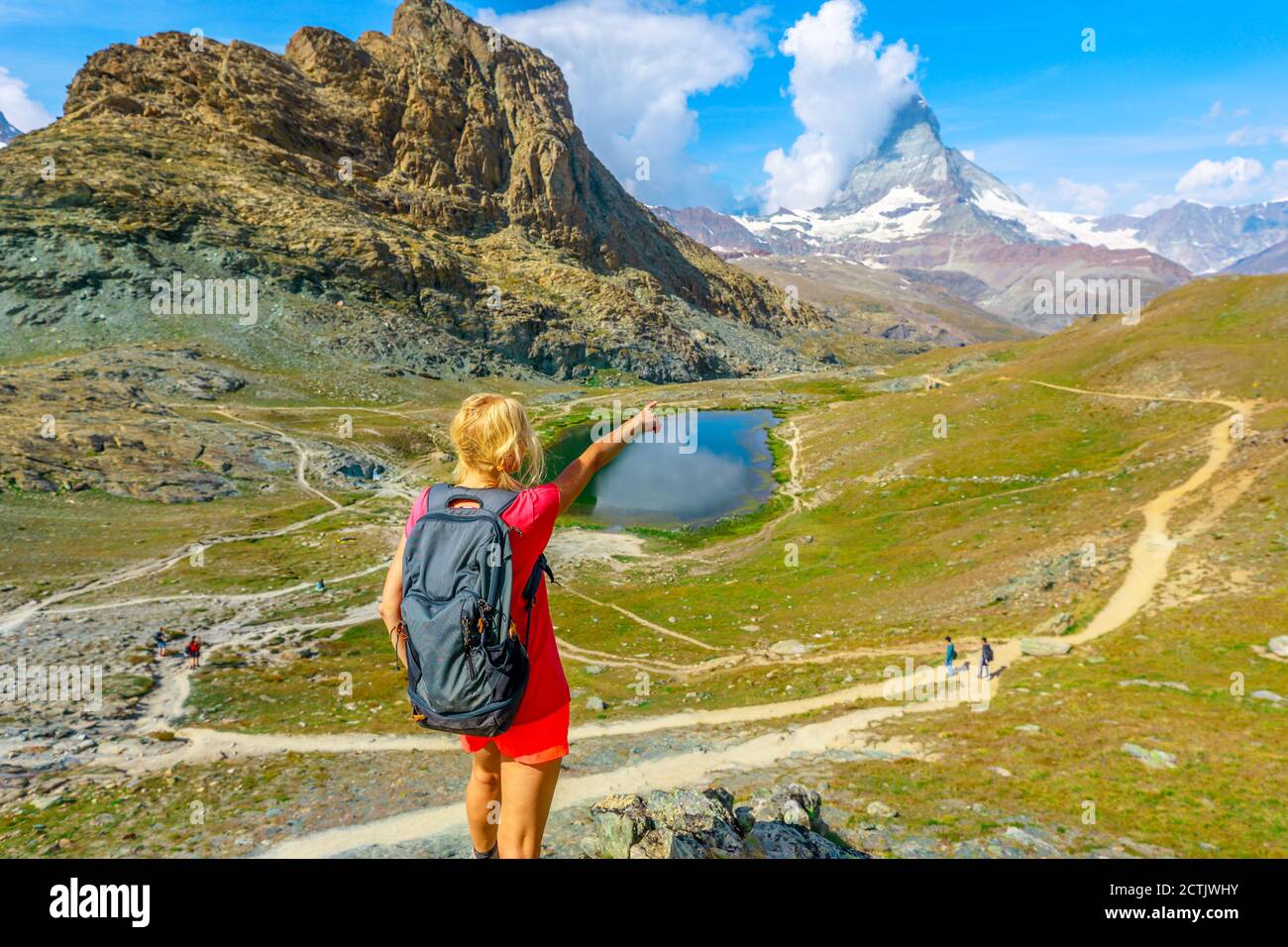 Une randonneur pointant vers le Mont Cervin ou Monte Cervino ou Mont Cervin, les Alpes suisses et le Lac Riffelsee. Activité en plein air à Zermatt Banque D'Images