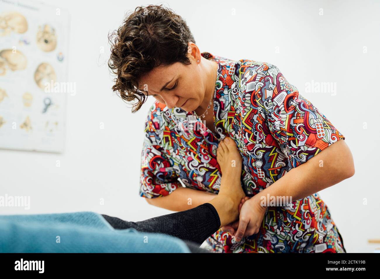 Sportswoman prenant un massage des pieds de l'ostéopathe au centre de santé Banque D'Images