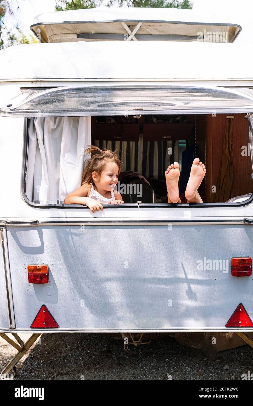 Fille regardant la sœur avec le pied sur la fenêtre dans le moteur accueil Banque D'Images