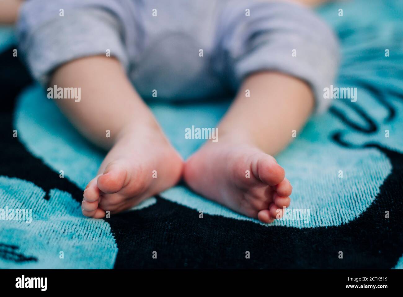 Gros plan des pieds de bébé garçon sur une couverture Banque D'Images