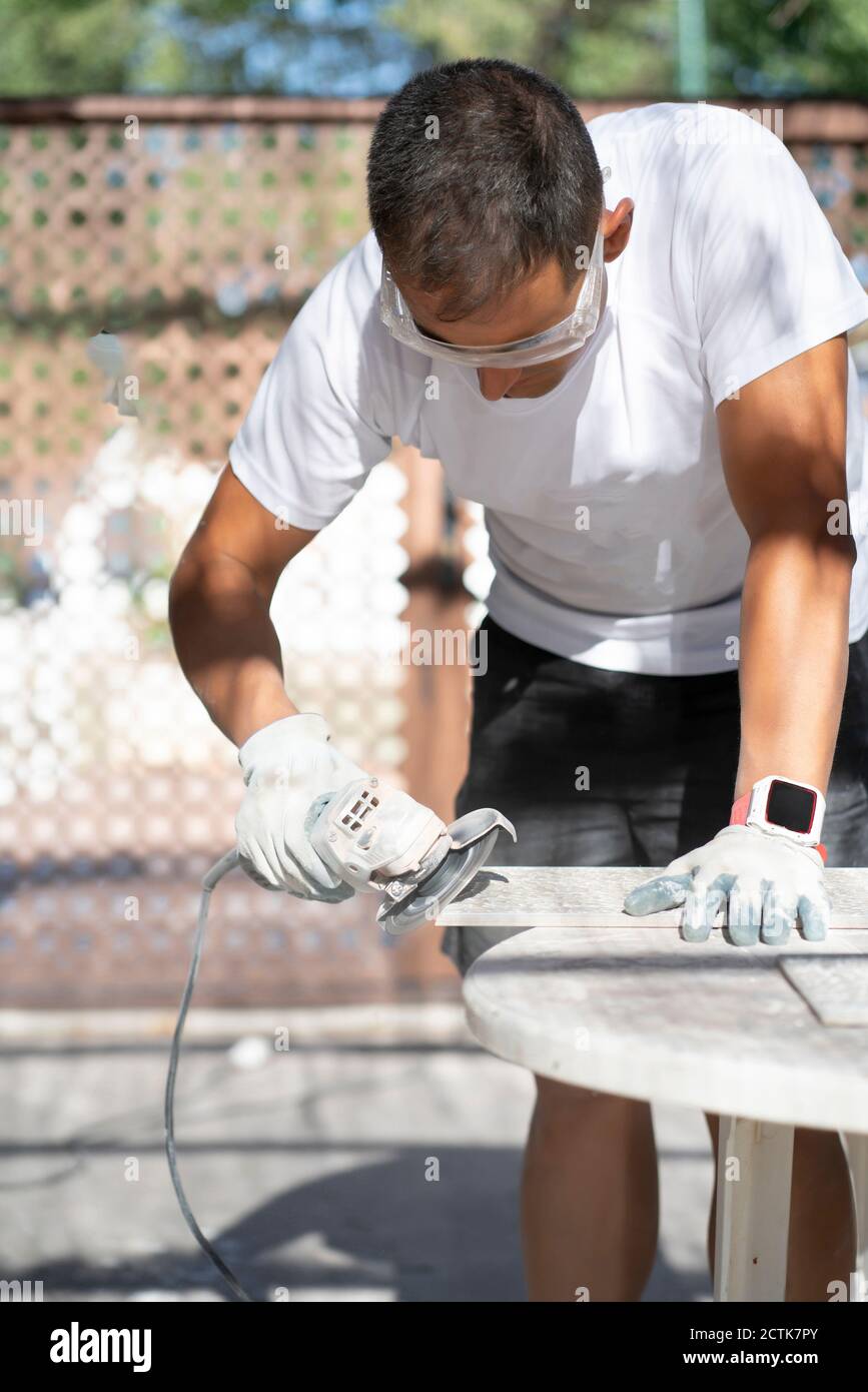 Homme utilisant une scie circulaire lors de travaux sur le chantier Banque D'Images