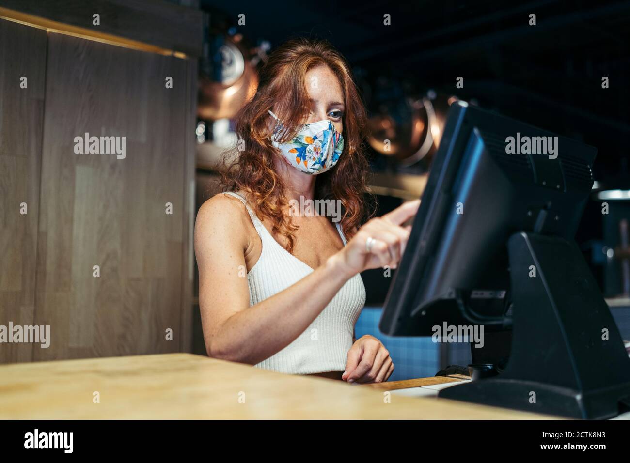 Serveuse prenant commande avec masque de protection sur le visage au restaurant Banque D'Images