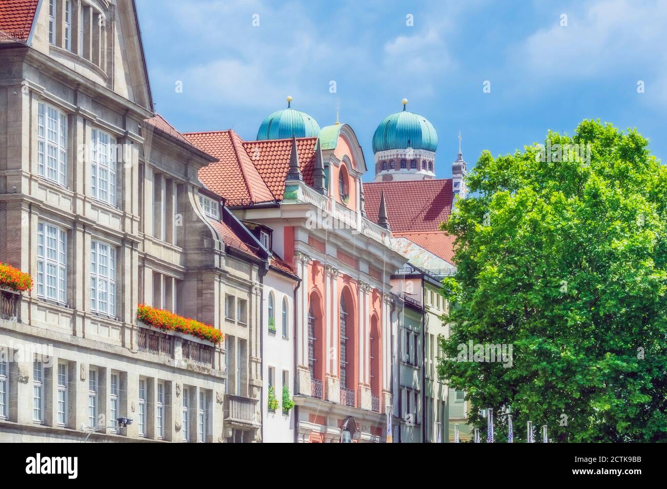 Allemagne, Bavière, Munich, rangée de maisons anciennes avec dômes de Frauenkirche en arrière-plan Banque D'Images
