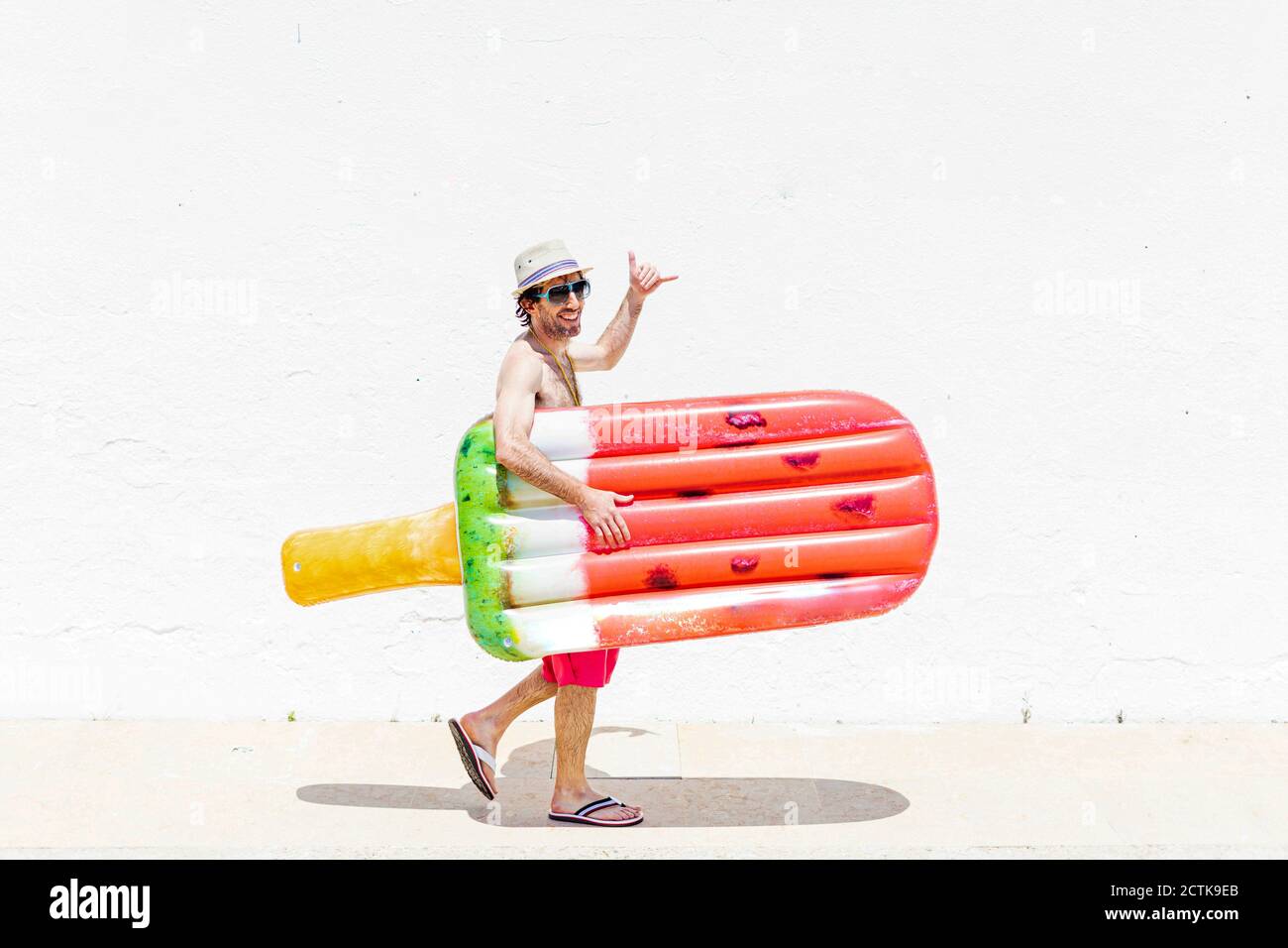 Un homme souriant fait pendre une affiche qui maintient le lit d'air en marche trottoir Banque D'Images
