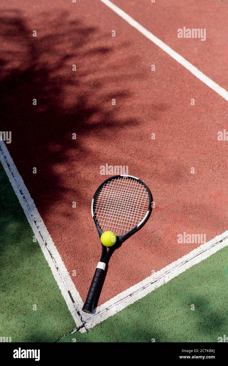 Ballon de tennis avec raquette sur le terrain de sport Banque D'Images