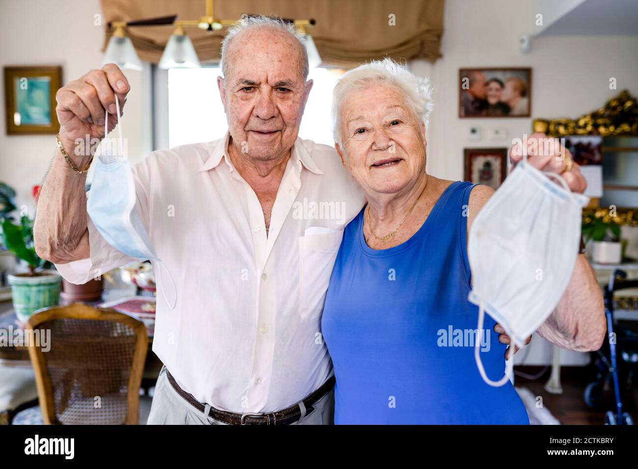 Couple senior tenant des masques de protection à la maison Banque D'Images