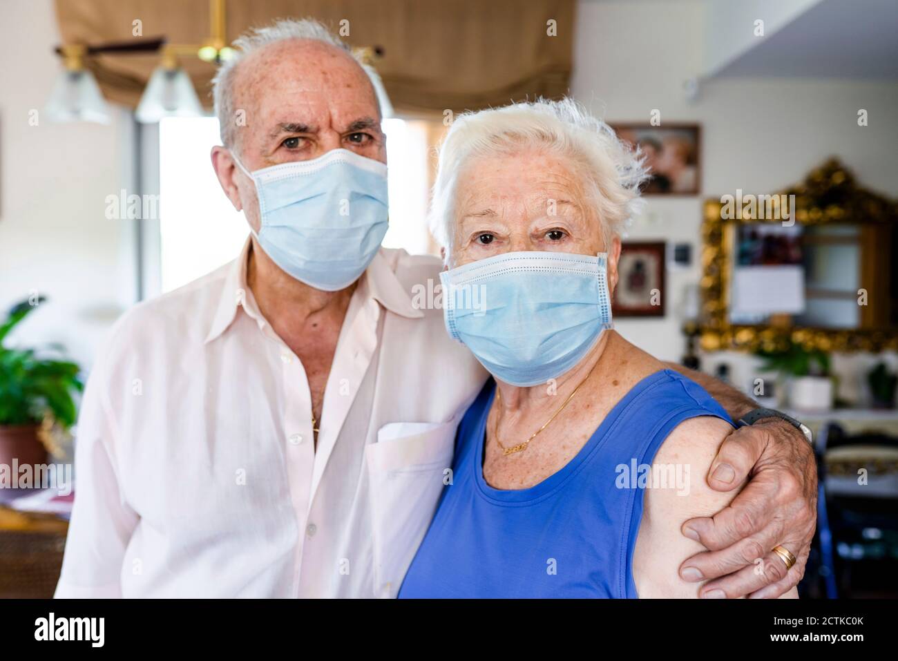 Couple senior portant des masques de protection à la maison Banque D'Images