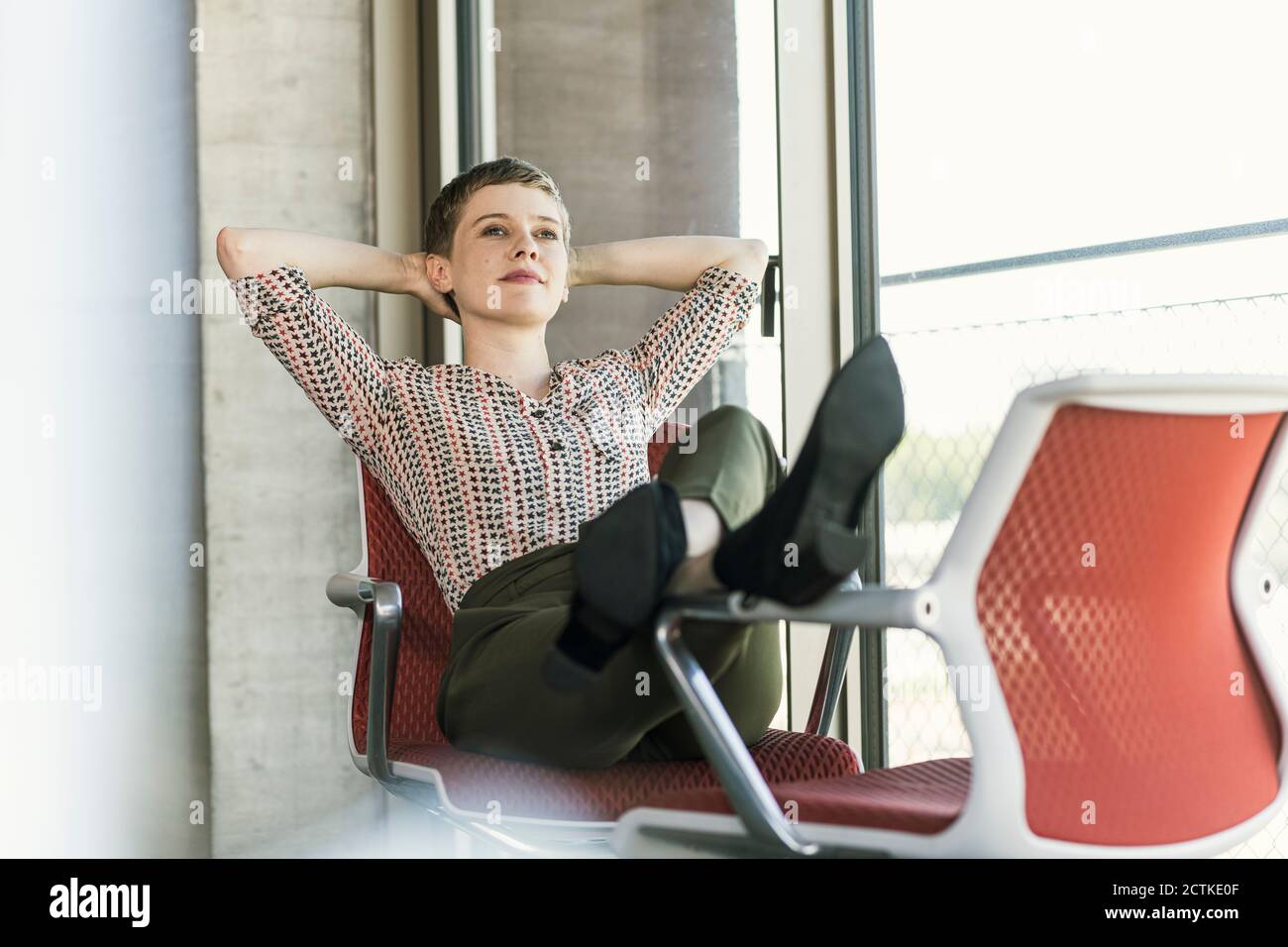 Femme d'affaires décontractée assise sur une chaise dans le bureau pour  faire une pause Photo Stock - Alamy