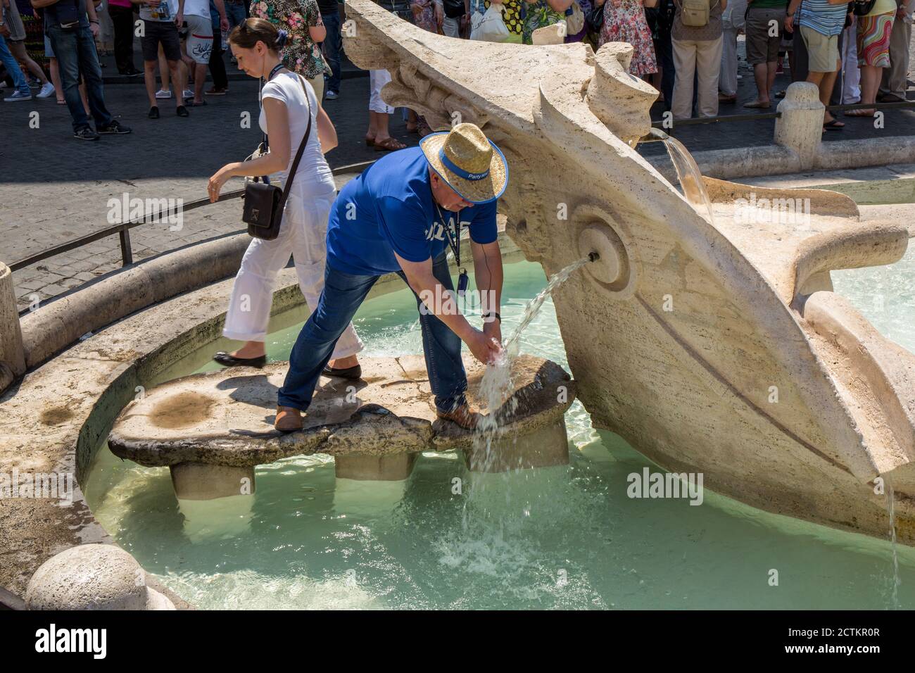 Rome, région du Latium, Italie. Homme remplissant une bouteille d'eau à la Fontana della Barcacia (qui peut être traduite en "Fontaine du bateau sans valeur" ou Banque D'Images