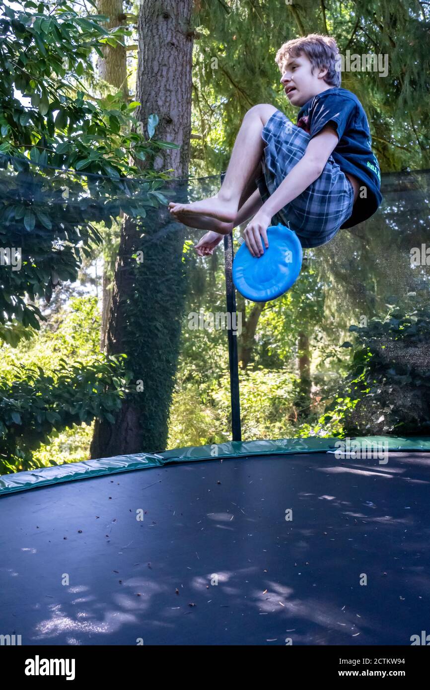 Lynwood, Washingtin, États-Unis. un garçon de 17 ans rebondit et se retourne sur son trampoline. Banque D'Images