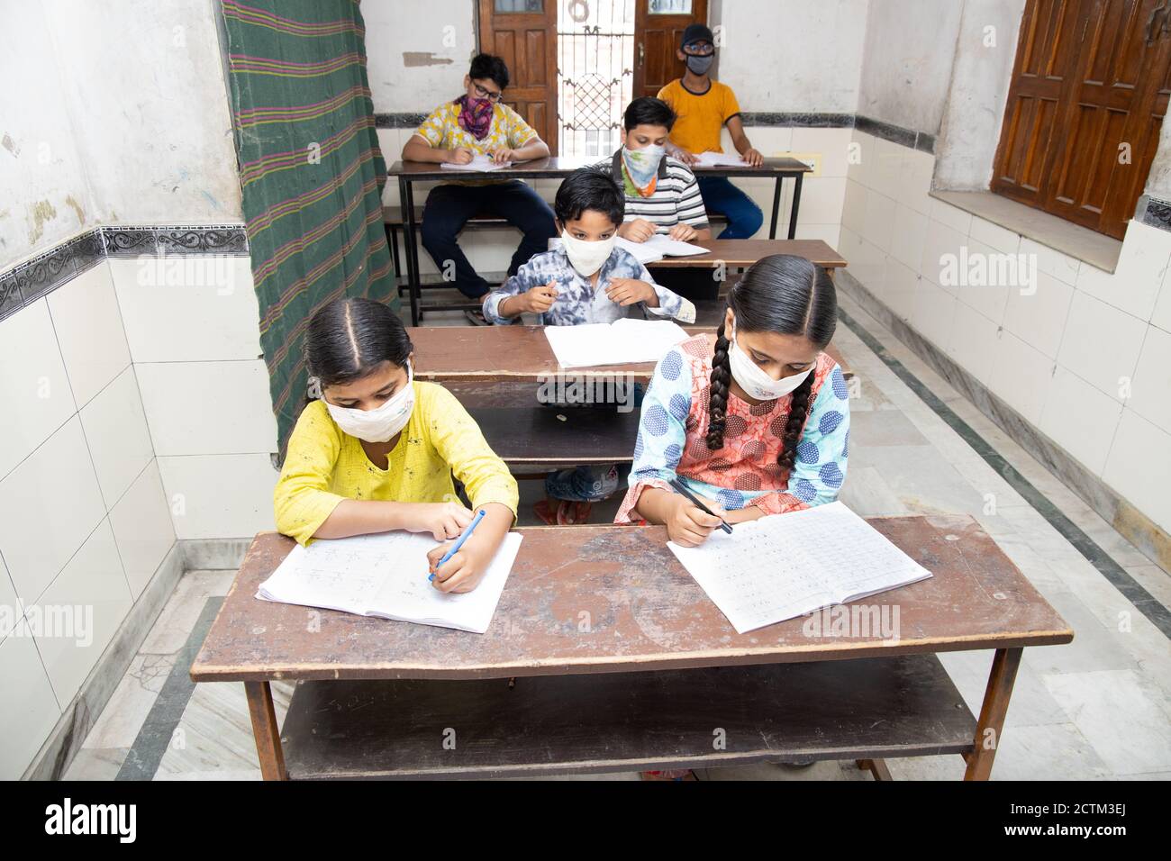 Élèves indiens étudiant en classe portant un masque et une distanciation sociale, l'école rouvre pendant la pandémie de covid19 Banque D'Images