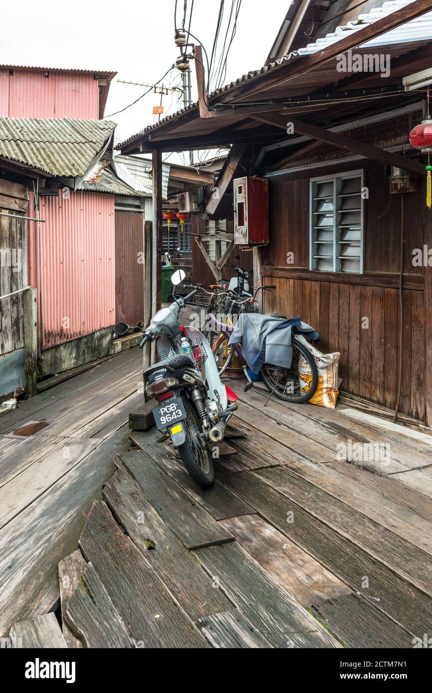 George Town, Penang, Malaisie - 1er décembre 2019 : moto et vélo sur un trottoir en bois du célèbre village de pêcheurs local Clan Tan Jetty à Geo Banque D'Images