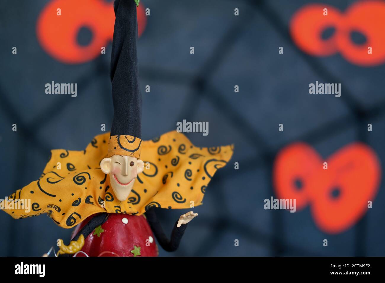 Arrière-plan de vacances d'Halloween.personnage coloré de freak sur fond sombre flou de toiles d'araignée et de lanternes de jack défocused Banque D'Images