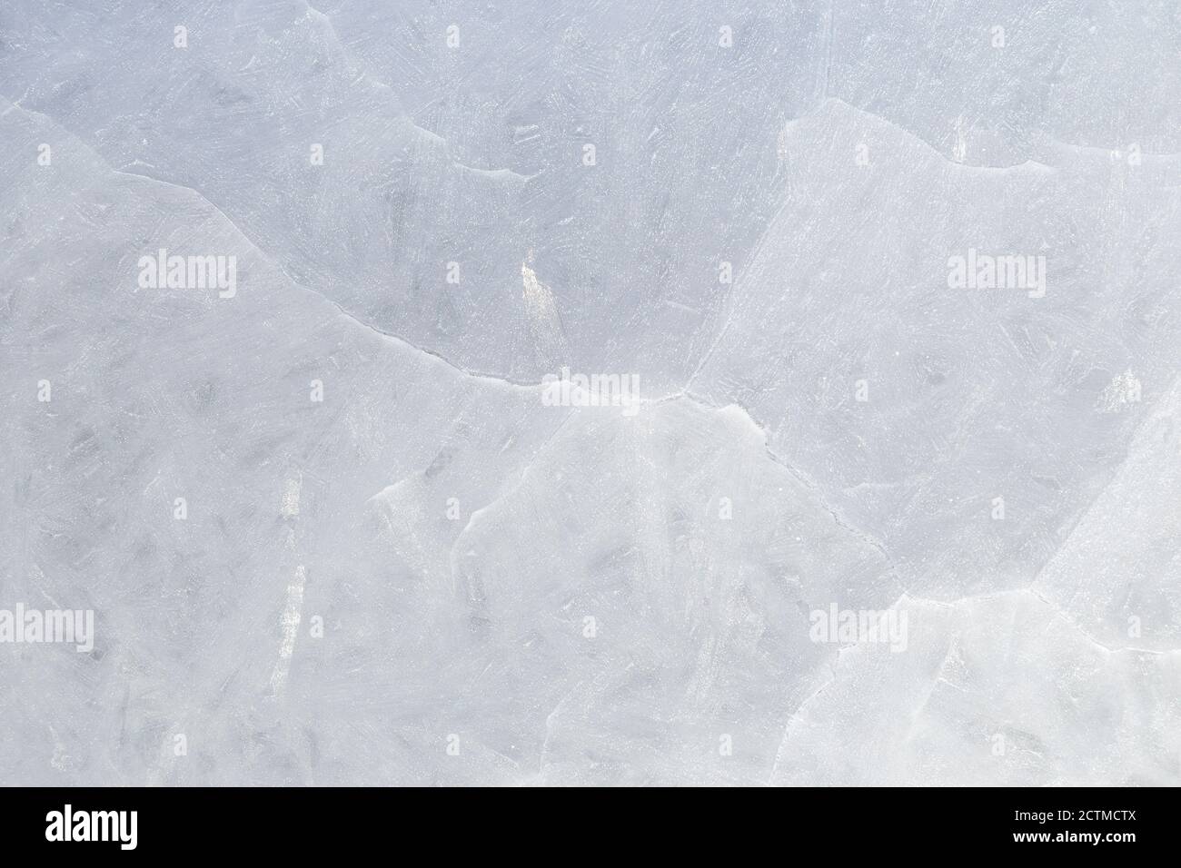 Gros plan de glace fissurée sur un lac gelé en hiver, vue d'en haut. Arrière-plan abstrait texturé plein cadre. Espace de copie, vue de dessus. Banque D'Images