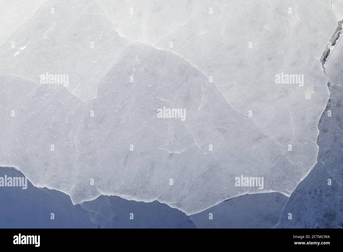 Gros plan de glace fissurée sur un lac gelé en hiver, vue d'en haut. Arrière-plan abstrait texturé plein cadre. Espace de copie, vue de dessus. Banque D'Images