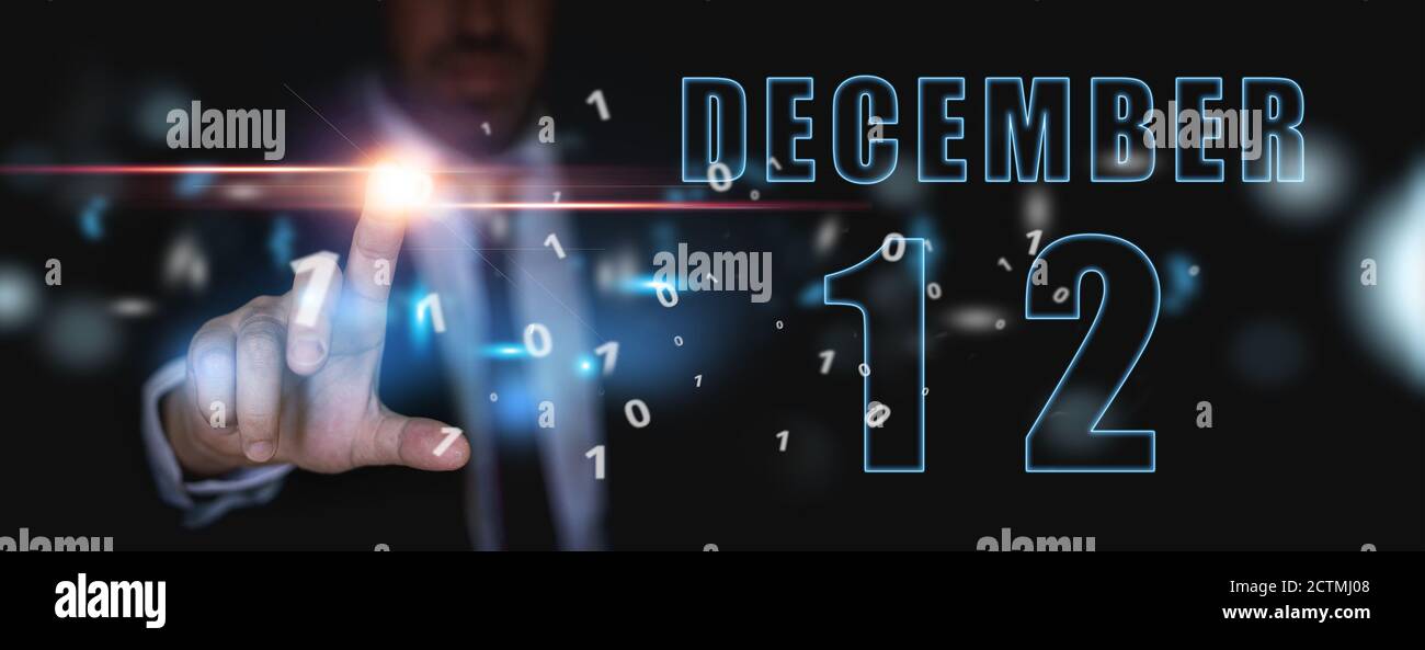 12 décembre. Jour 12 du mois, publicité ou calendrier high-tech, homme en costume appuie sur le bouton virtuel lumineux hiver mois, jour de l'année concept. Banque D'Images