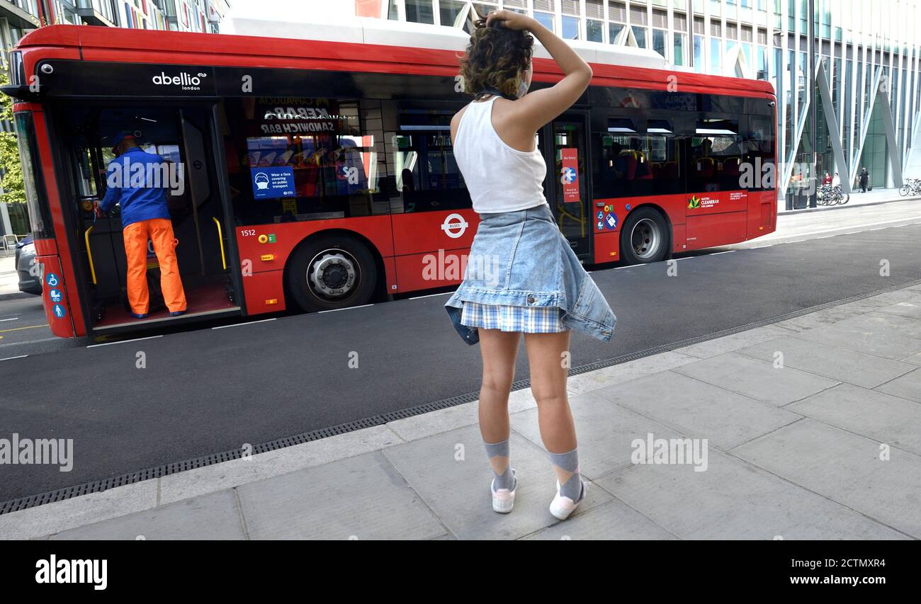 Londres, Angleterre, Royaume-Uni. Une jeune femme sur son téléphone  portable à un arrêt de bus à Victoria Photo Stock - Alamy