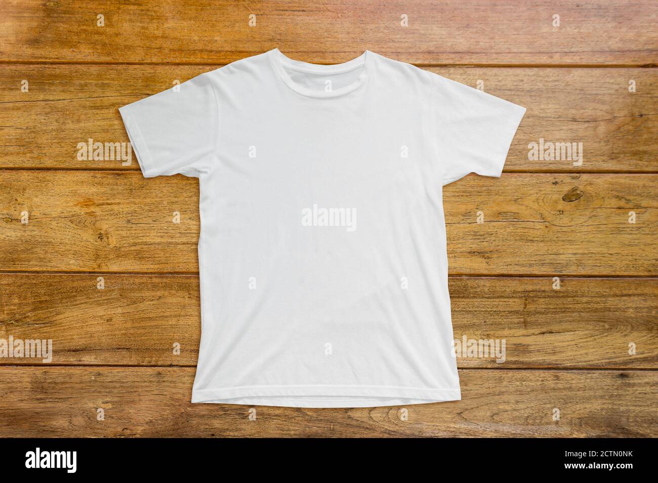 Maquette de t-shirt blanc sur fond de gabarit en bois. Banque D'Images