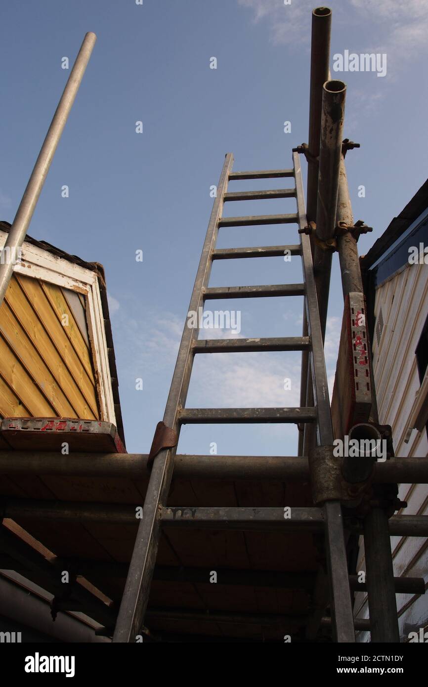 Une vue depuis un échafaudage de l'extrémité de pignon réparée d'une ancienne maison en bois, avec un toit en ardoise, qui a encore besoin d'être peint, et d'anciennes barges Banque D'Images