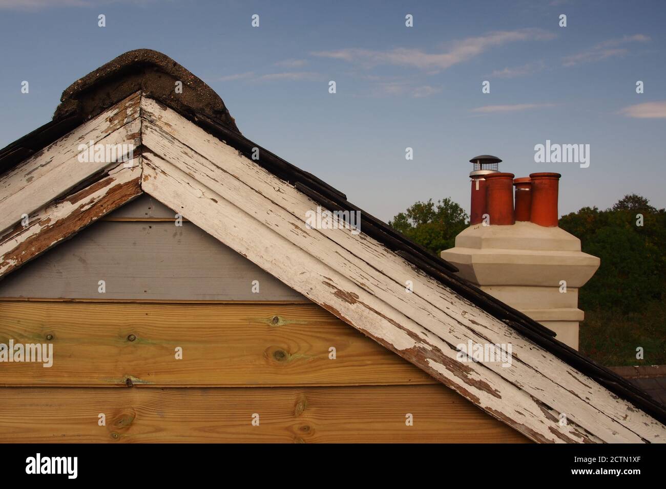 Une vue depuis un échafaudage de l'extrémité de pignon réparée d'une ancienne maison en bois, avec un toit en ardoise, qui a encore besoin d'être peint, et d'anciennes barges Banque D'Images