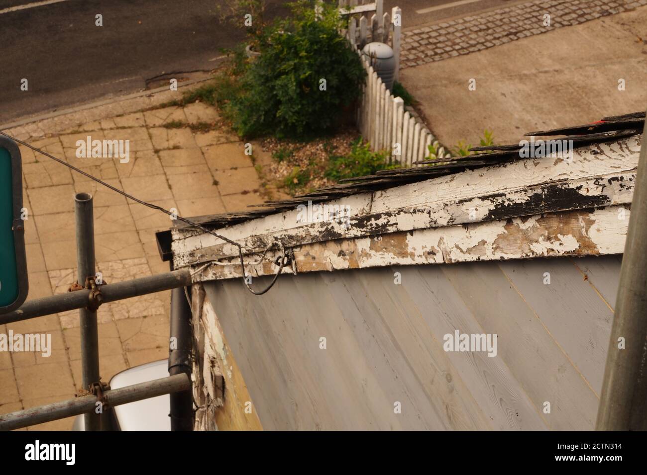 Une vue rapprochée depuis un échafaudage regardant sur la longueur d'une barge sur une ancienne maison en bois ajoutée nécessitant des réparations, du ponçage et de la peinture Banque D'Images