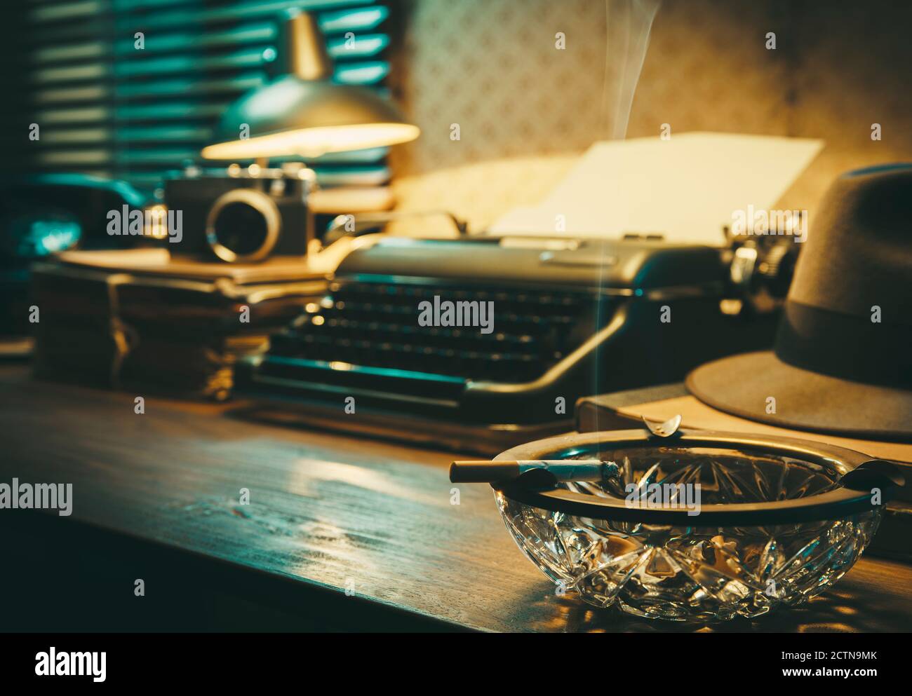 Bureau avec machine à écrire vintage, cigarette et cendrier, style noir des années 1950 Banque D'Images