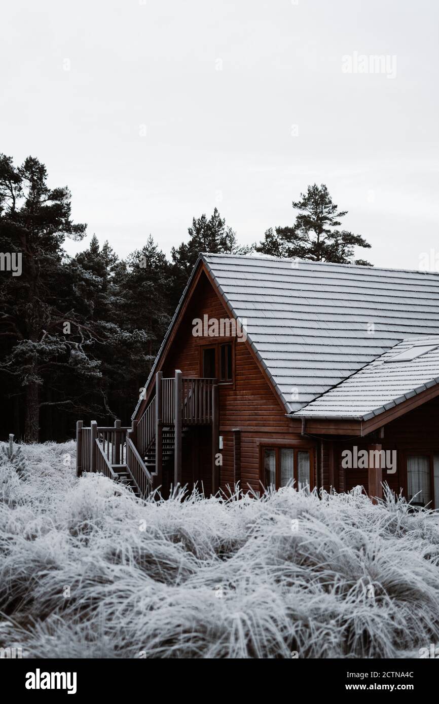 Chalet résidentiel avec façade en bois situé dans le village Hiver dans les Highlands écossais Banque D'Images