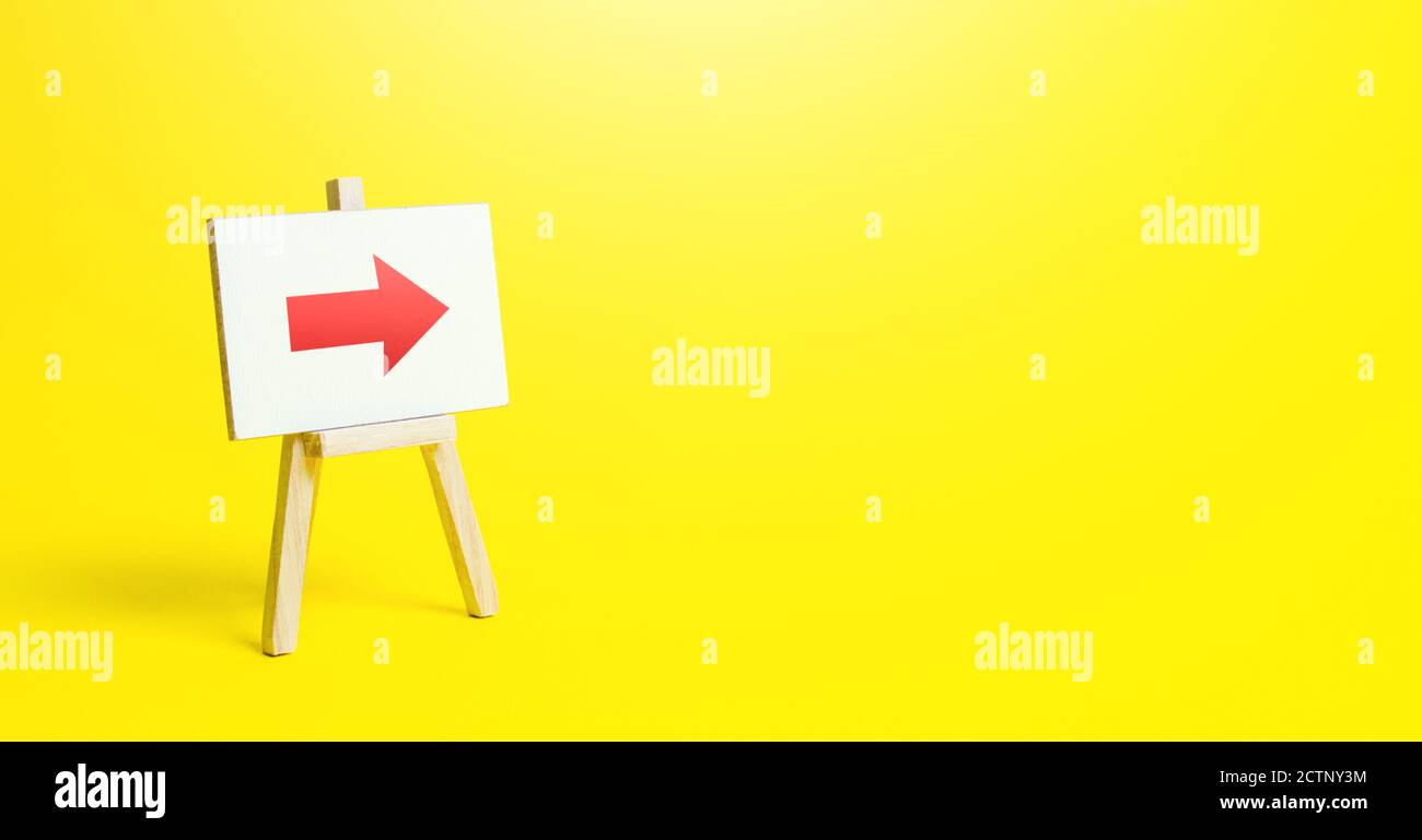 Chevalet avec une flèche droite rouge sur fond jaune. Signe de direction. Publicité de l'emplacement d'un magasin ou d'un point de vente. Minimalisme. Restriction de m Banque D'Images