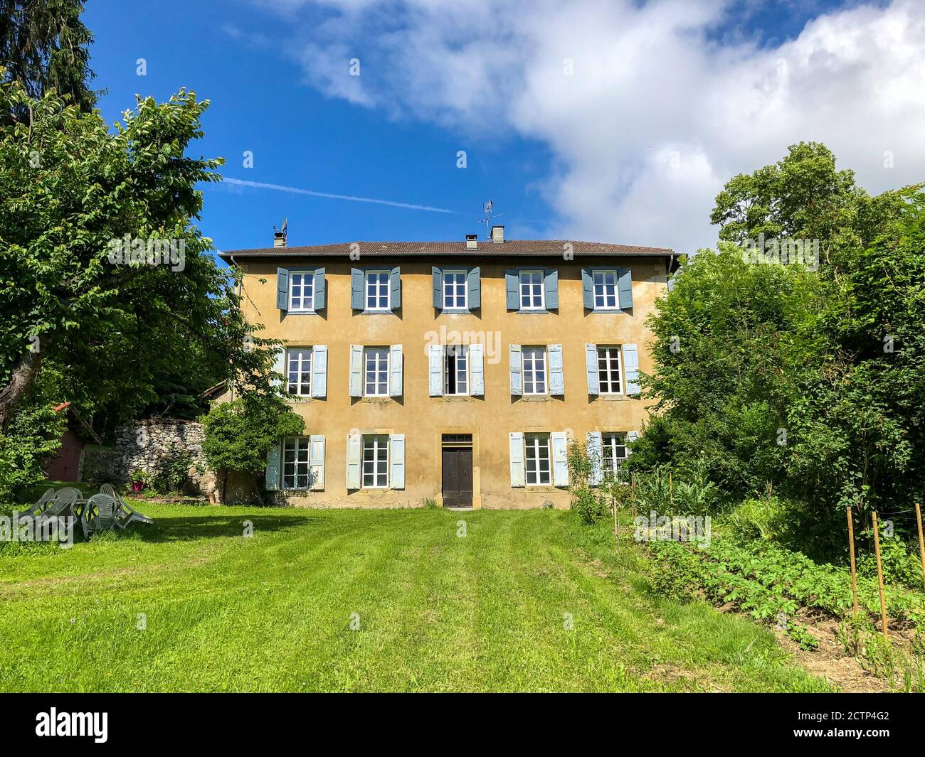 Ancien manoir français avec volets et pelouse, dans les collines accidentées de l'Ariège Banque D'Images