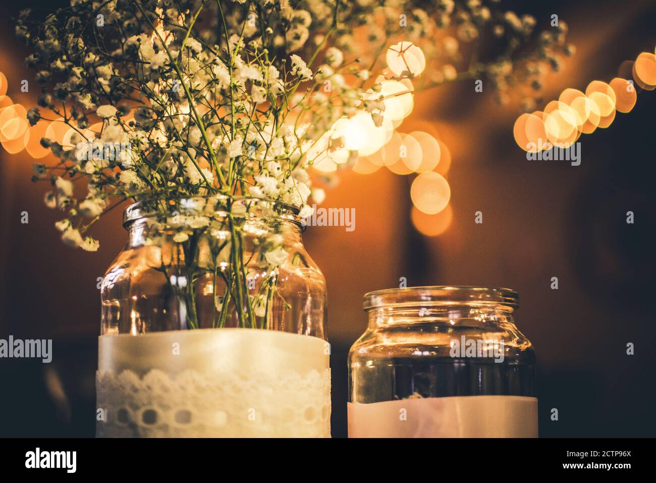 Fleurs blanches de mariage dans un pot assis sur une table Banque D'Images