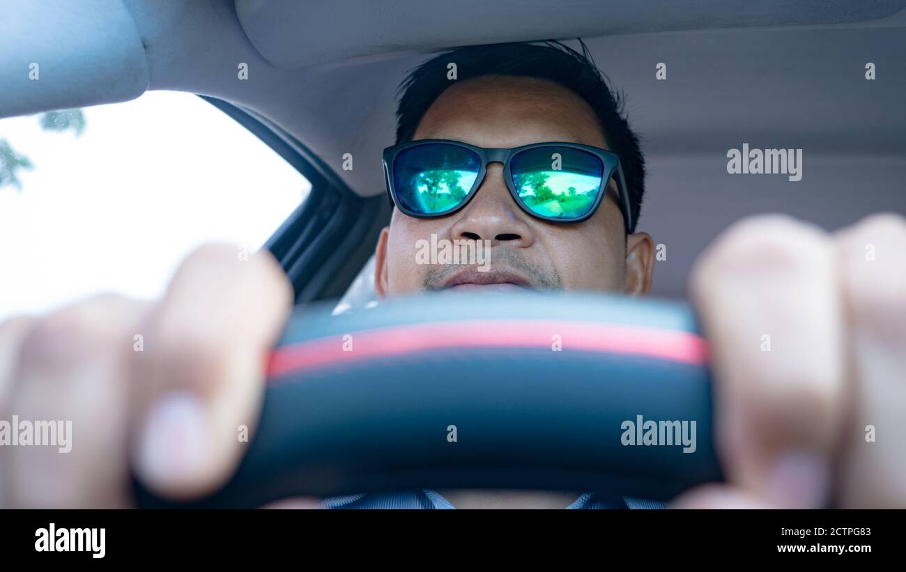 Homme conduisant dans la voiture avec des lunettes de soleil Banque D'Images