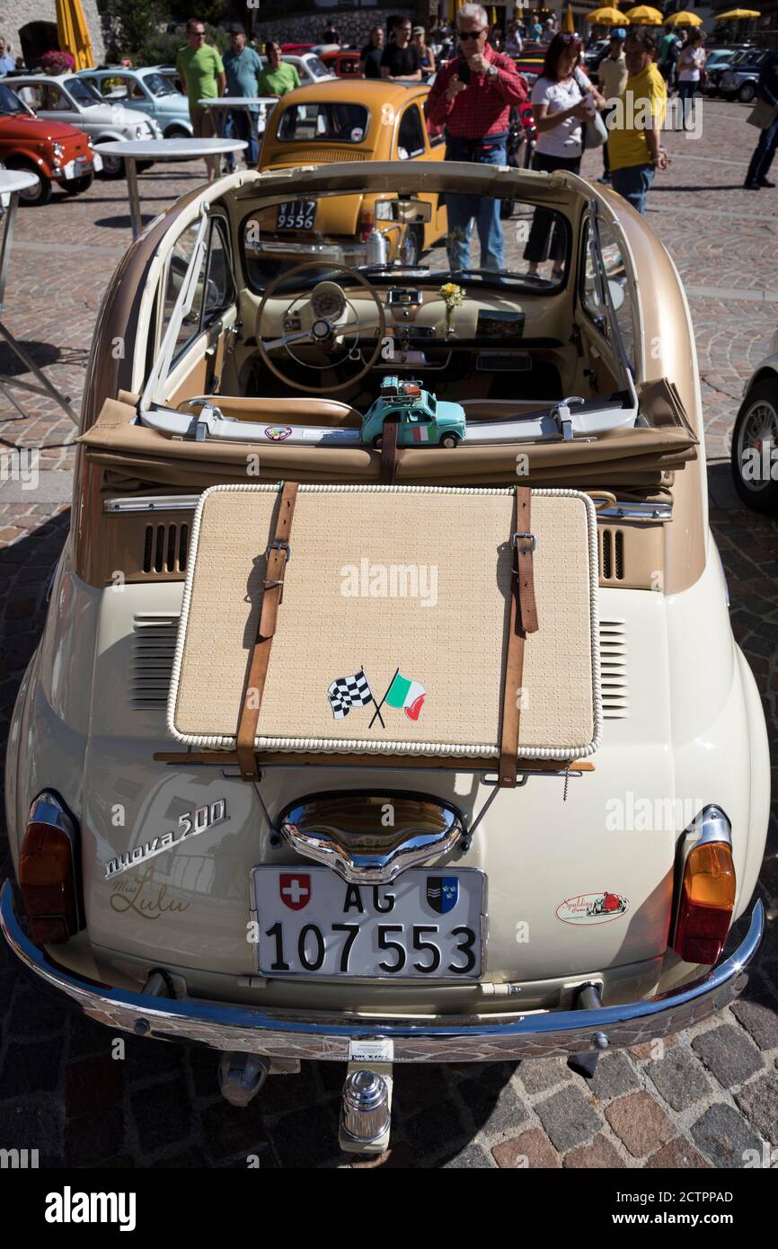 Une ancienne valise attachée à l'arrière d'une Fiat 500 vintage avec le  toit ouvrant replié, l'une des nombreuses sur un rallye sur la place du  village de Selva va va Photo Stock -