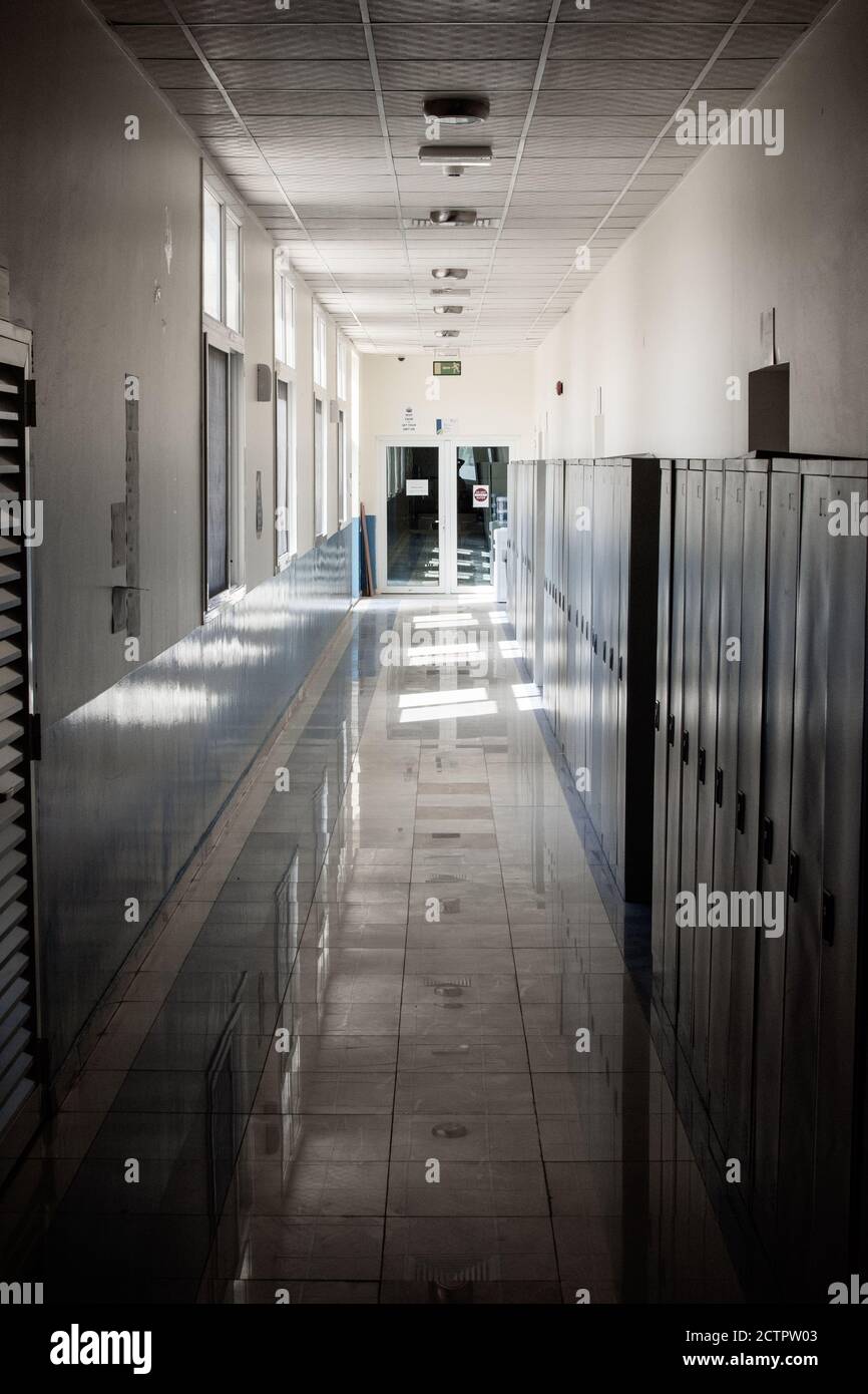 Couloir vide d'une école secondaire ou d'un collège fermé pendant la COVID-19 (coronavirus). Casiers flous dans le couloir solitaire. Banque D'Images