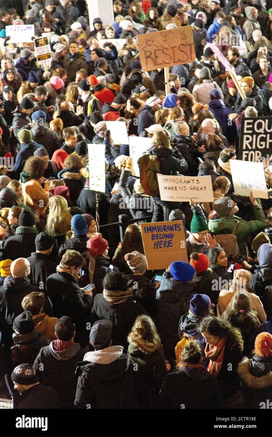Vue à grand angle de la foule qui porte des panneaux de protestation contre l'interdiction de voyager musulmane, aéroport JFK, New York, New York, États-Unis Banque D'Images