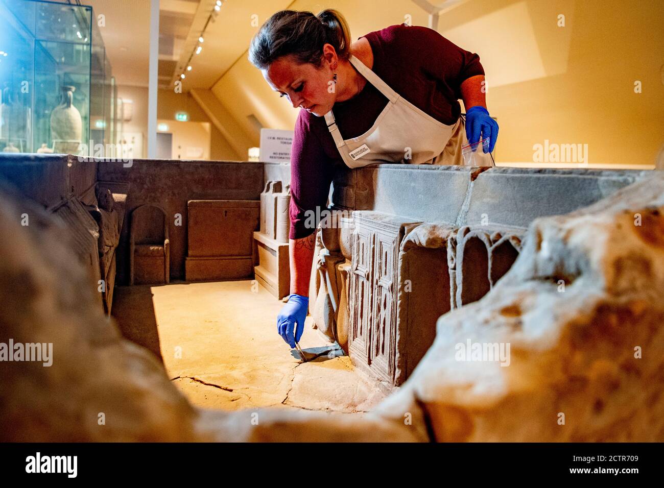 Un employé travaillant sur le sarcophage pendant la restauration.UN sarcophage romain cassé au Musée national des antiquités de Leiden est en cours de restauration. La boîte en grès de 2.5 mètres a été trouvée en 1930 à Simpelveld, à Limbourg. Des recherches antérieures sur le matériel osseux ont établi que la femme incinérée avait entre 35 et 50 ans lorsqu'elle est décédée et qu'elle avait vécu une bonne vie sans travail acharné. Banque D'Images