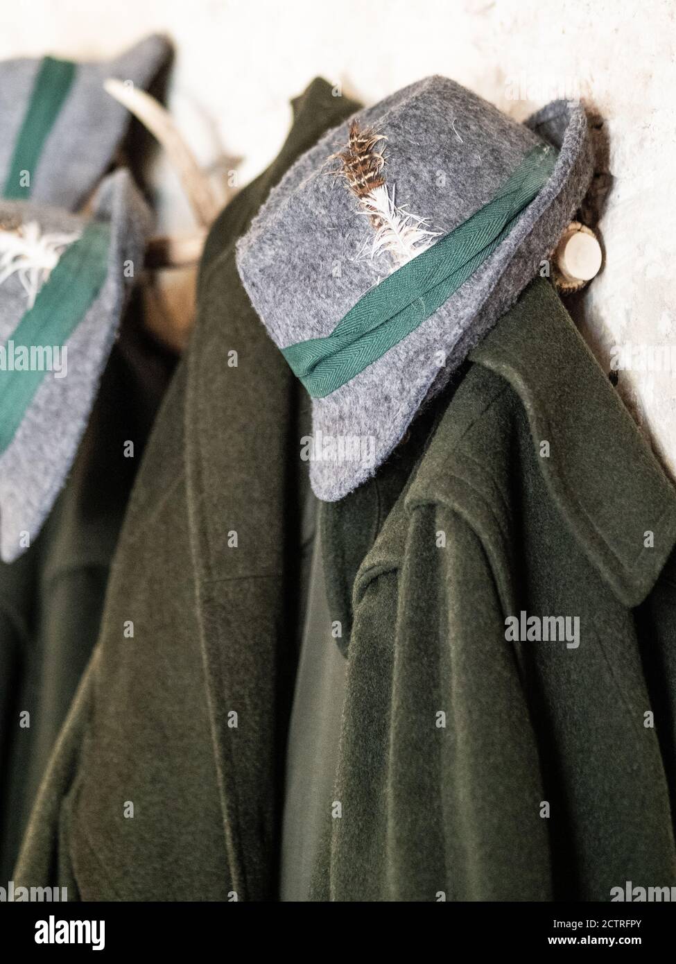Manteau de chasseur vert traditionnel et chapeau gris avec plume accrochée  sur le porte-manteau. Concept de chasse Photo Stock - Alamy