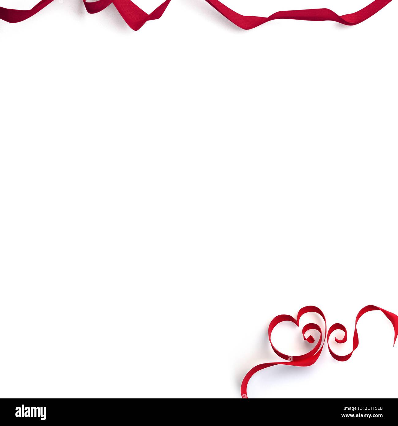 Noeud rouge décoratif et rubans en forme de coeur sur fond blanc. Vacances, décoration de Saint-Valentin. Lié au cadeau. Cadre avec espace de copie. Banque D'Images