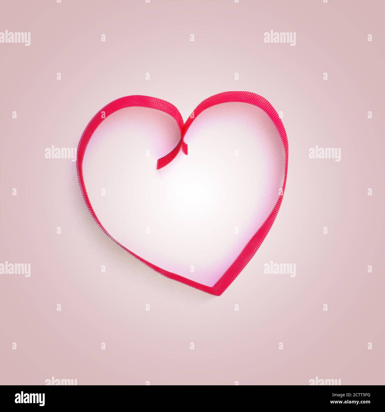 Noeud rouge décoratif et rubans en forme de coeur sur fond rose. Vacances, décoration de Saint-Valentin. Lié au cadeau. Cadre avec espace de copie. Banque D'Images