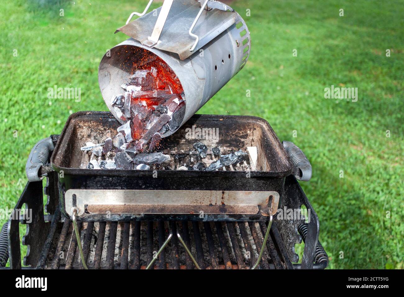 gros plan d'une cheminée à charbon de bois remplie de morceaux de charbon rouge flambants. La cheminée est soulevée de sa poignée et la hutte rouge brûlante c Banque D'Images