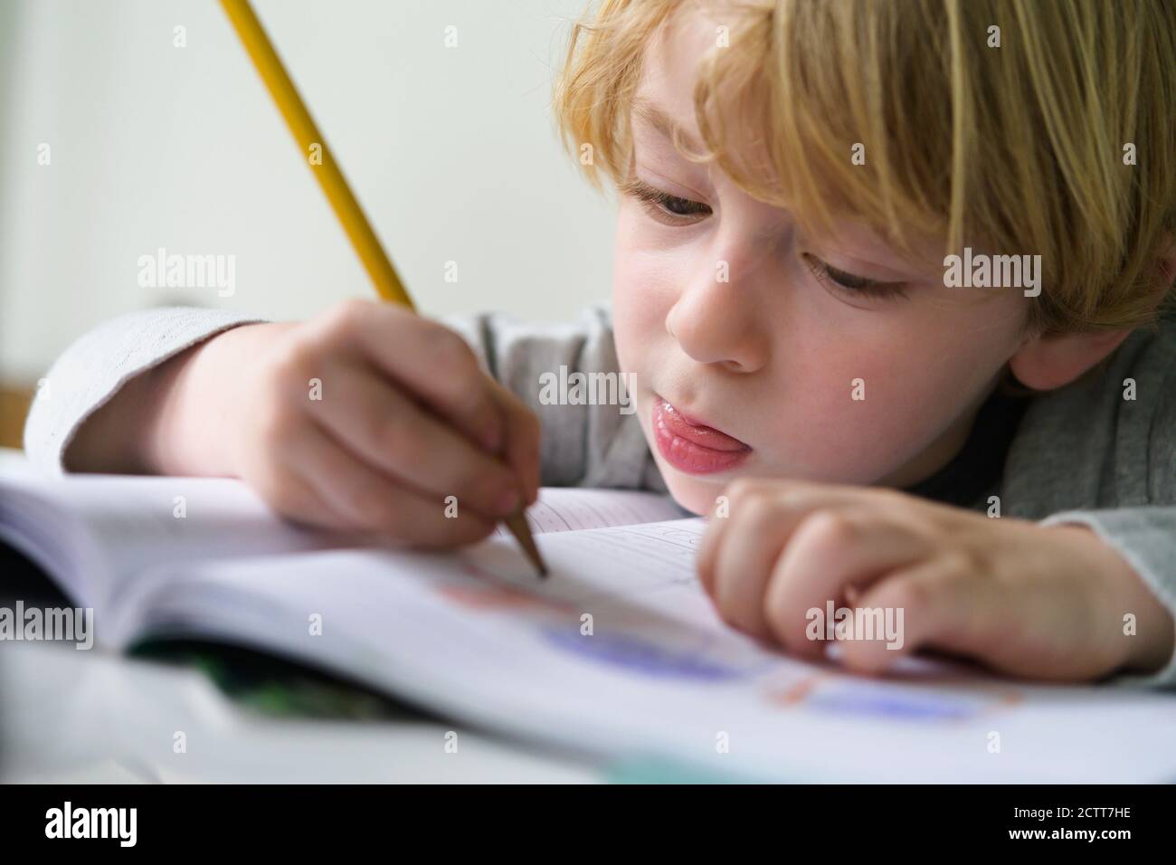Garçon (4-5) faisant des devoirs Banque D'Images