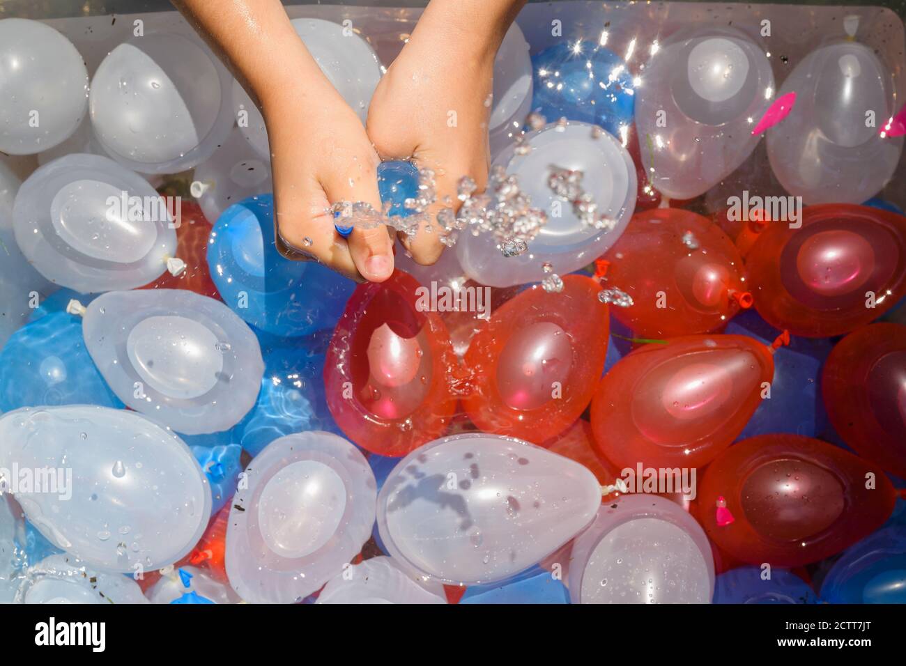 Gros plan de fille (6-7) jouant avec des ballons d'eau Banque D'Images