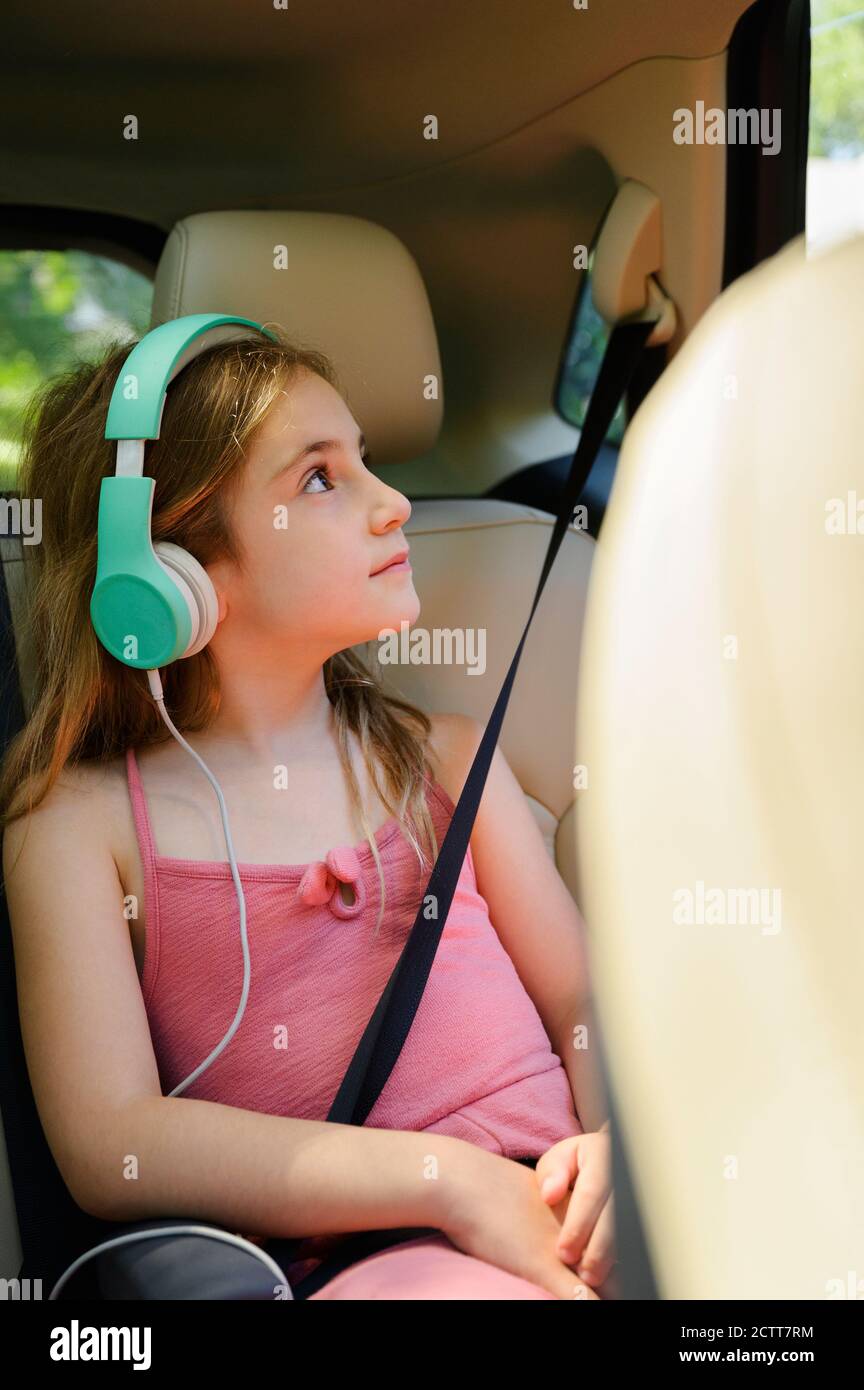 Fille (6-7) écoutant de la musique en voiture Banque D'Images