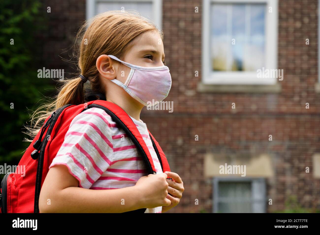 Écolière (6-7) portant un masque de grippe Banque D'Images