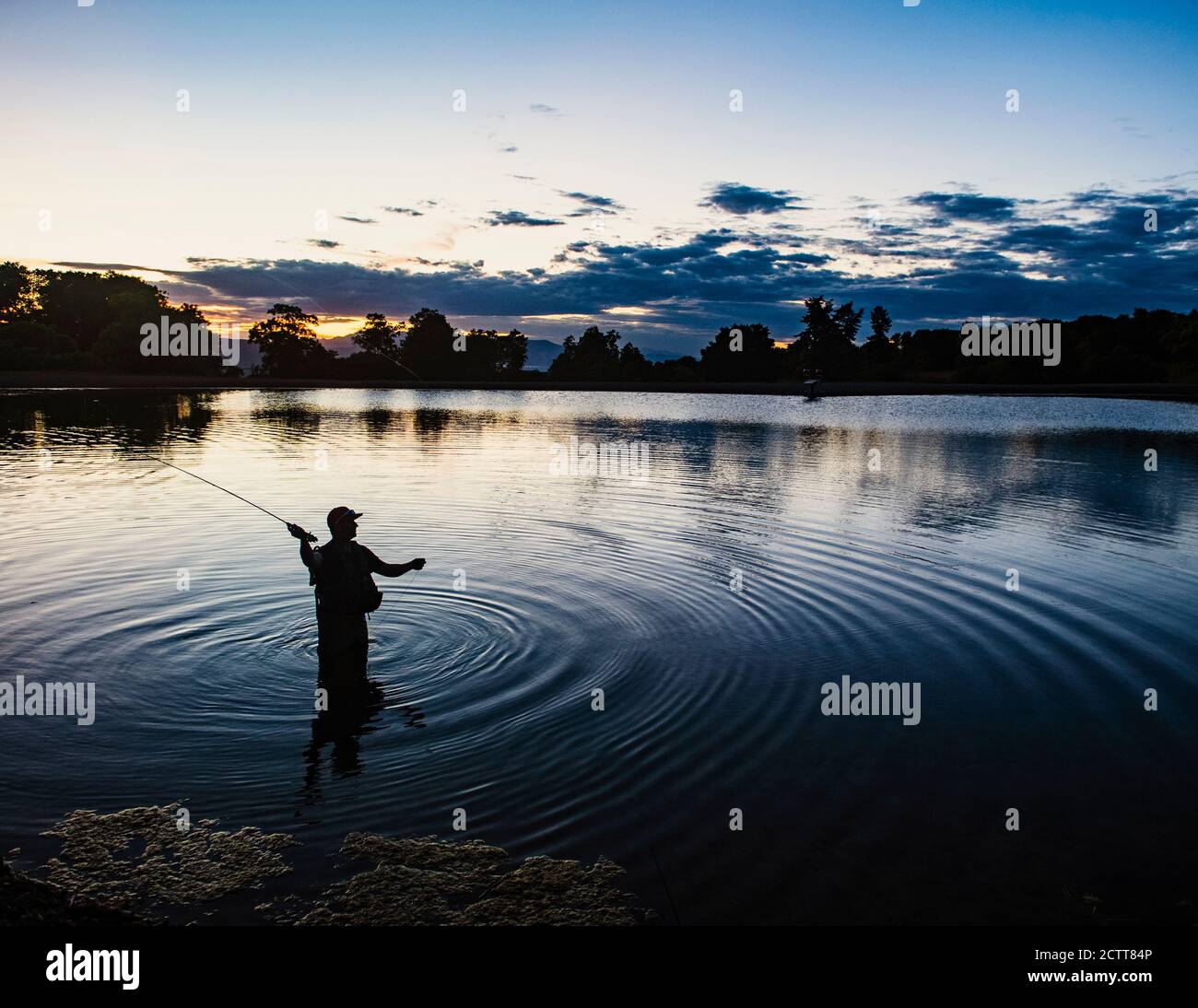 États-Unis, Utah, Salem, Silhouette of man pêche à la mouche dans le lac au crépuscule Banque D'Images