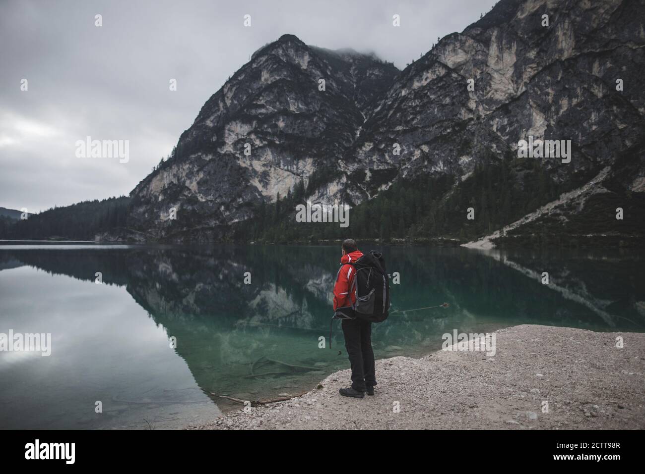 Italie, Pragser Wildsee, Dolomites, Tyrol du Sud, Homme regardant la vue debout près du lac de montagne Banque D'Images