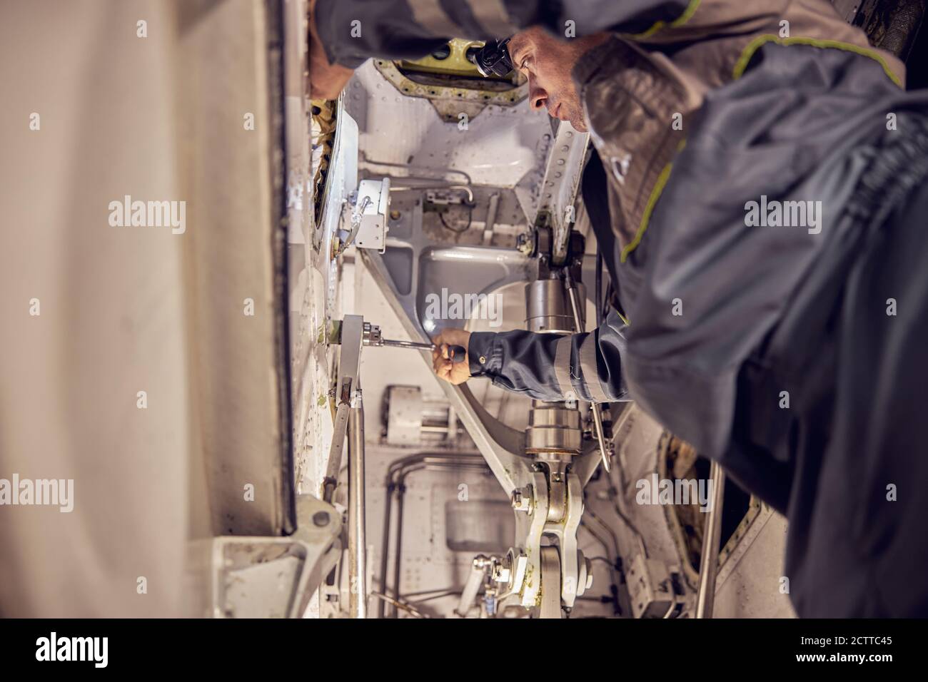 Un technicien répare le circuit hydraulique et vérifie la puissance du système dans l'avion Banque D'Images