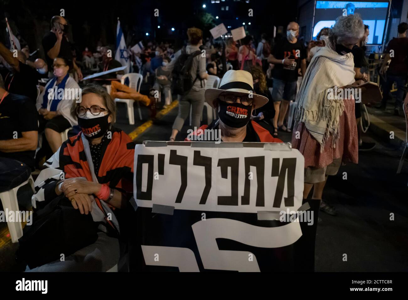 JÉRUSALEM, ISRAËL - 24 SEPTEMBRE 2020 : Un manifestant tient un écriteau qui indique « nous prions, partez » alors que les manifestants s'assoient sur des chaises, conformément aux réglementations de distance sociale lors d'une manifestation à l'extérieur de la résidence officielle de Benyamin Netanyahou, dans le cadre d'un confinement à l'échelle nationale visant à enrayer la pandémie du coronavirus le 24 septembre 2020 à Jérusalem, en Israël. Une vague de protestations a balayé Israël au cours des derniers mois pour exiger la démission de Netanyahou suite à son inculpation pour corruption et à la gestion de la pandémie du coronavirus. Banque D'Images