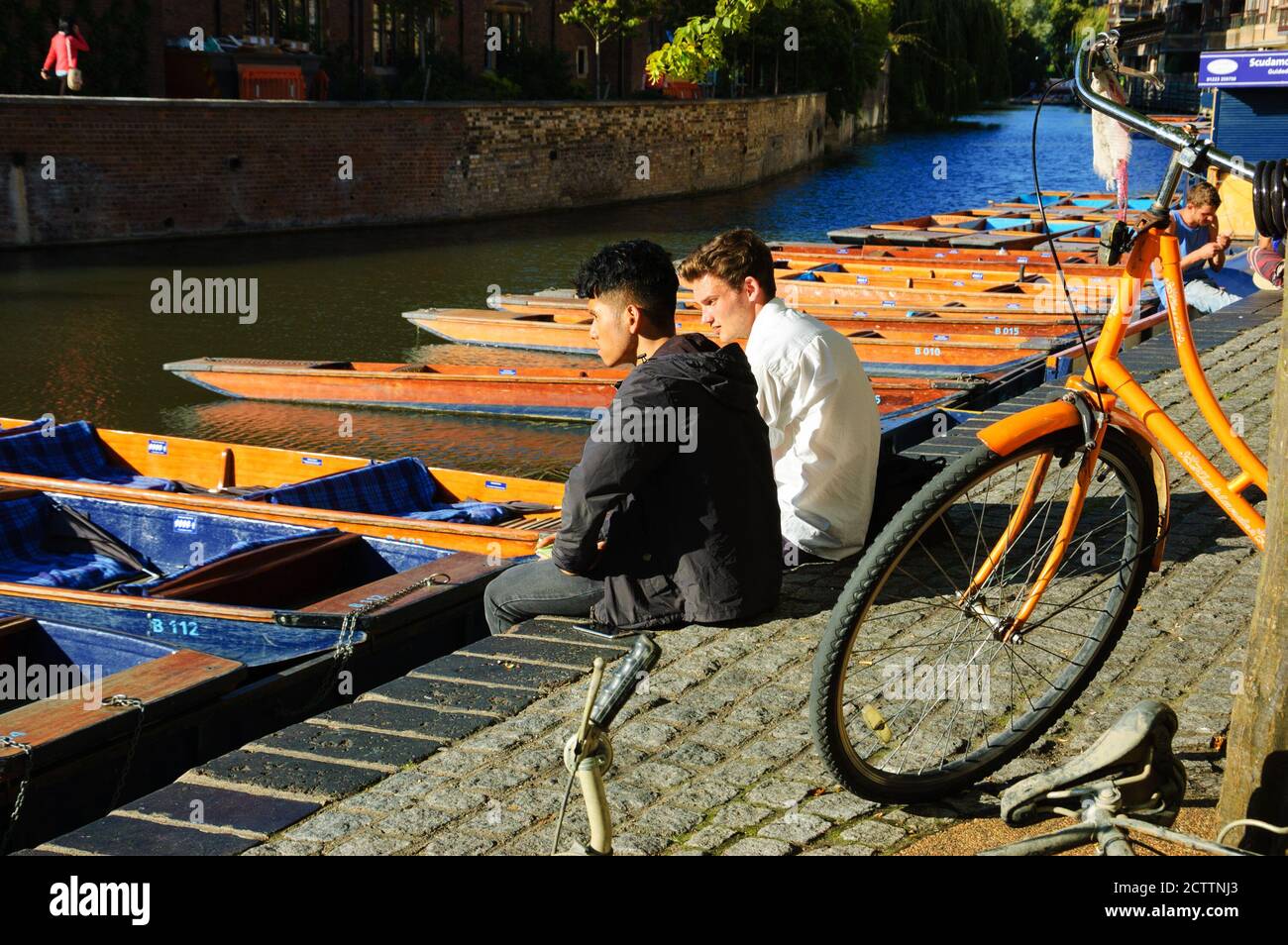 CAMBRIDGE, Royaume-Uni : deux étudiants se reposant sur un quai de punting. Le punting (le punting tour est une attraction touristique populaire) est un travail commun parmi les étudiants de Cambridge Banque D'Images