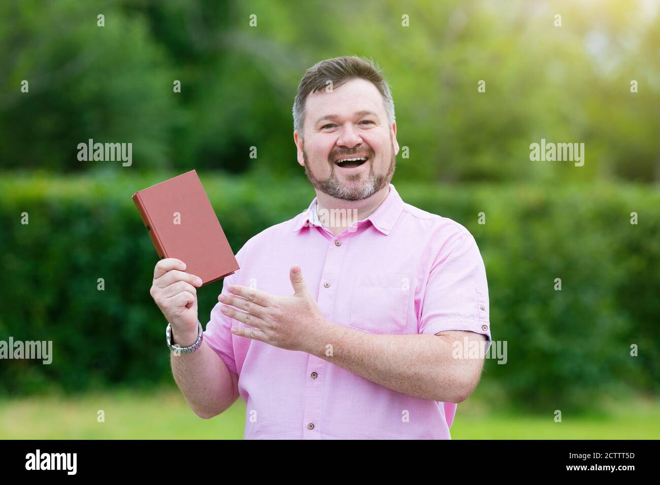 Un homme recommande de vendre un bon livre dans la rue du parc. Banque D'Images